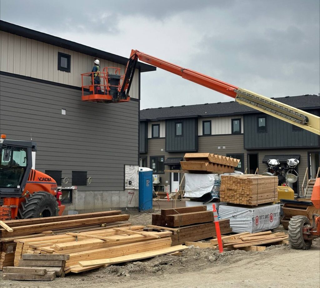 Commercial and residential siding installation using a boom lift in Saskatoon.